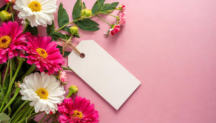 Mock up of empty white tag label and beautiful spring flowers on pink background, flat lay