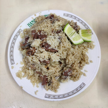 Old Dhaka famous Hanif Biriyani tehari a traditional  rice item of Bangladesh cooked with mutton, beef served in white bowl wooden background. 