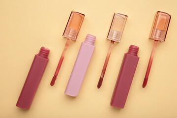 Beautiful lip glosses on a beige background
