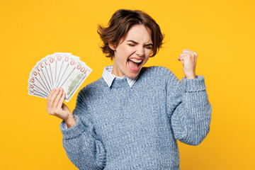 Young woman wears grey knitted sweater shirt casual clothes hold in hand fan of cash money in...