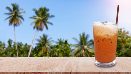 Iced thai milk tea in glass, Milk ice tea, Cheddar is a traditional Thai drink on wooden table with...