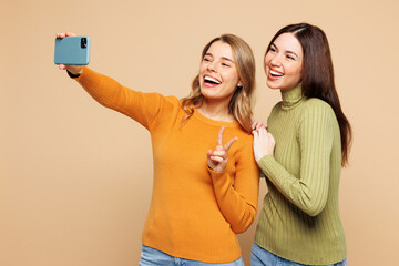 Young happy friends two women they wear orange green shirt casual clothes together doing selfie...
