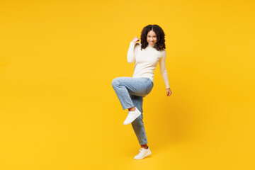 Fototapeta na wymiar Full body little kid teen girl of African American ethnicity wear white casual clothes doing winner gesture celebrate clenching fists isolated on plain yellow background. Childhood lifestyle concept.