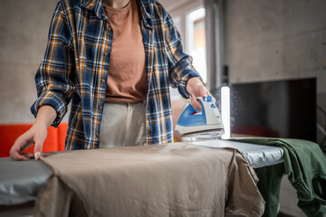 one woman ironing clothes at home hold iron household chores concept