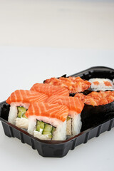 Close-up of sushi rolls made of sausage and covered with cabbage and ketchup. Homemade asian style. Sushi-food hybrids trend. Japanese food.