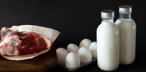 Fototapeta na wymiar meat, eggs and milk over black backround