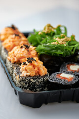 Close-up of sushi rolls made of sausage and covered with cabbage and ketchup. Homemade asian style. Sushi-food hybrids trend. Japanese food.