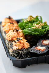Close-up of sushi rolls made of sausage and covered with cabbage and ketchup. Homemade asian style. Sushi-food hybrids trend. Japanese food.