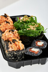 Close-up of sushi rolls made of sausage and covered with cabbage and ketchup. Homemade asian style. Sushi-food hybrids trend. Japanese food.