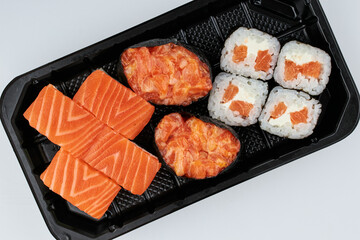 Close-up of sushi rolls made of sausage and covered with cabbage and ketchup. Homemade asian style. Sushi-food hybrids trend. Japanese food.