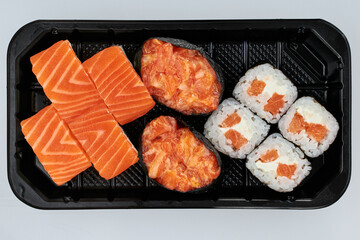 Close-up of sushi rolls made of sausage and covered with cabbage and ketchup. Homemade asian style. Sushi-food hybrids trend. Japanese food.