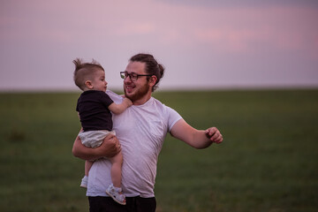 Heartwarming scene of diversity father carrying smiling son on shoulders at twilight, showcasing affection, familial bonds. Tender Father Son Embrace. Close up portrait, copy space. Fathers day