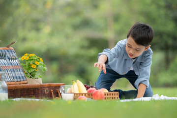 Happy family enjoying a picnic in the park, with children having fun sitting, surrounded by nature