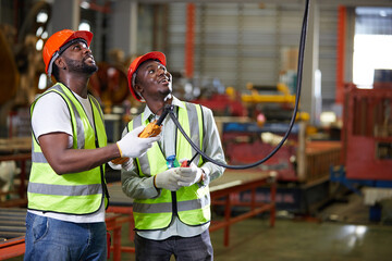 factory workers or engineers operating remote switch to control machine in the factory