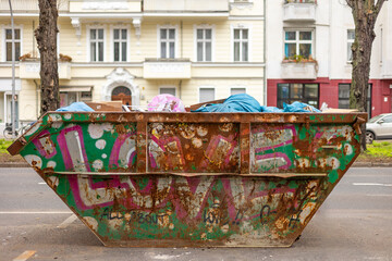 Rostiger Container mit Müllsäcken auf der Straße