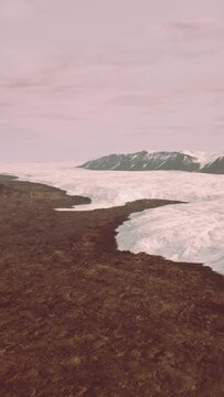 An aerial view of a glacier with mountains in the background