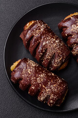 Delicious sweet chocolate cakes with fruit filling and sprinkles on a ceramic plate