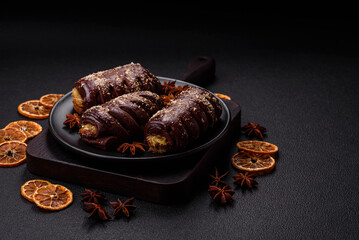 Delicious sweet chocolate cakes with fruit filling and sprinkles on a ceramic plate