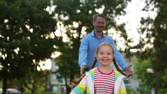 happy father runs through park behind little daughter, happy family, child kid girl running father, happy smile running child sunset, joy, become healthy and energetic, parent, children race, running