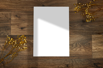 Blank A4 photorealistic brochure mockup wooden table with shadow window and gypsophila flowers
