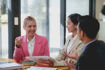 Group of Asian business people discussing business plans at a meeting.