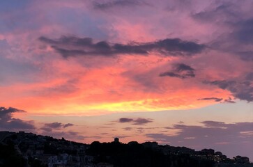 Dramatic sky sunset clouds above old town at evening.