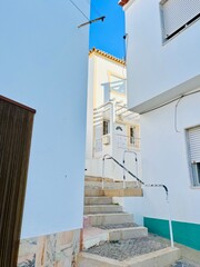 Fototapeta na wymiar Houses with white walls, small and cozy sea town, streets of an traditional Portuguese sea town 