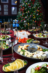 Dinner plate of dorblu cheese, parmesan, brie cheese, honey and walnuts, Greek salad of fresh cucumber, tomato, sweet pepper, lettuce, feta cheese and olives.