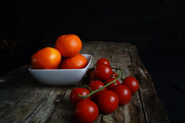 Still life photography with cherry tomatoes and mandarins