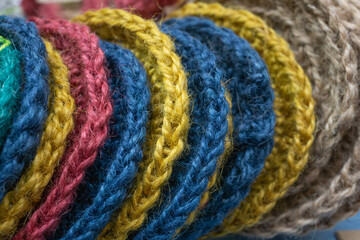 Textured jute elements for cup holders or shower washcloths in yellow blue sand colors close up at an angle.