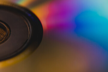 vista macro sulla superficie colorata di un disco cd rom che riflette vari colori dello spettro elettromagnetico sulla sua superficie - obrazy, fototapety, plakaty