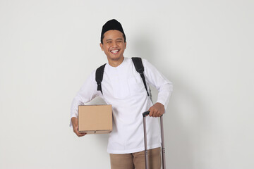 Portrait of excited Asian muslim man in koko shirt with peci carrying cardboard box and holding...