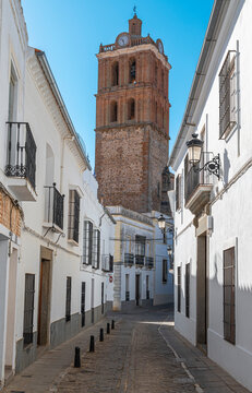 Una calle peatonal de casas blancas en la villa espa&ntilde;ola de Zafra con el campanario de la parroquia de la Candelaria, Espa&ntilde;a