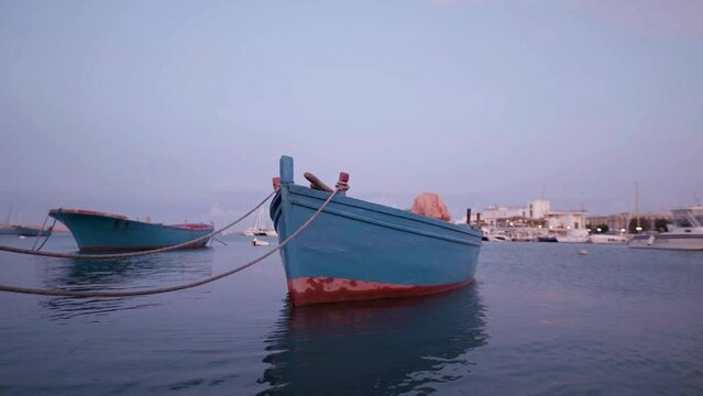 wooden boat moored with calm sea at dawn
