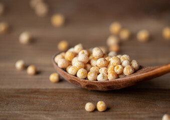 Organic Dried Yellow Whole Peas on a Wooden Spoon. Pulses Variety. Raw Uncooked Legumes Concept.
