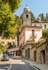 Fototapeta na wymiar Street with view of the bell tower of the San Giacomo church in the picturesque village Bellagio on Lake Como, Lombardy, Italy