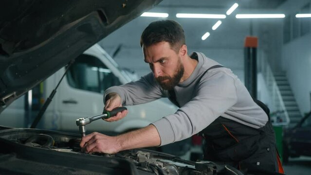 Professional auto mechanic engineer Caucasian man working in vehicle service engine specialist fixing motor automobile using spanner key wrench tool repair car broken truck in garage workshop station