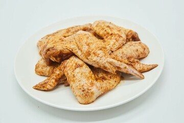 Raw meat chicken wings in spices on a white background. Different parts of meat products for different dishes.