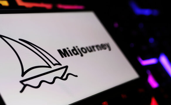 Viersen, Germany - February 9. 2024: Closeup of Smartphone screen with logo lettering of Midjourney AI text-to-image tool on computer keyboard
