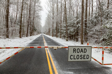 Gate with Road Closed Sign during a Winter Snow - 750138508