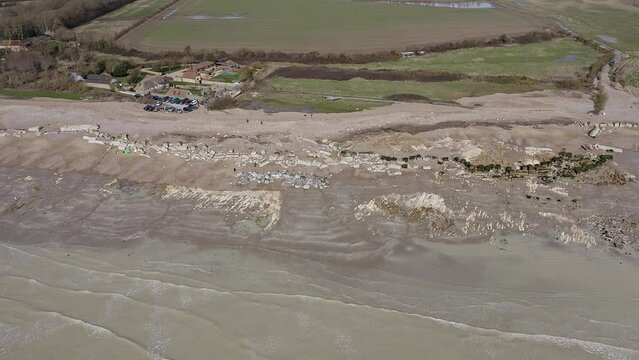 Atherington and Climping beach in West Sussex and the broken sea defence and the temporary shingle bank in place to protect the land, aerial footage.