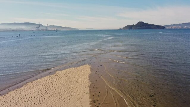 Beach in the Pontevedra estuary with the island of Tambo in the background. Recorded with drone. 4k