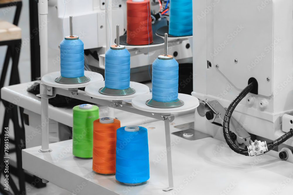 Aufkleber spools of color threads closeup, spinning machine