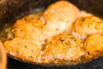 Red fish meatballs are fried in a frying pan