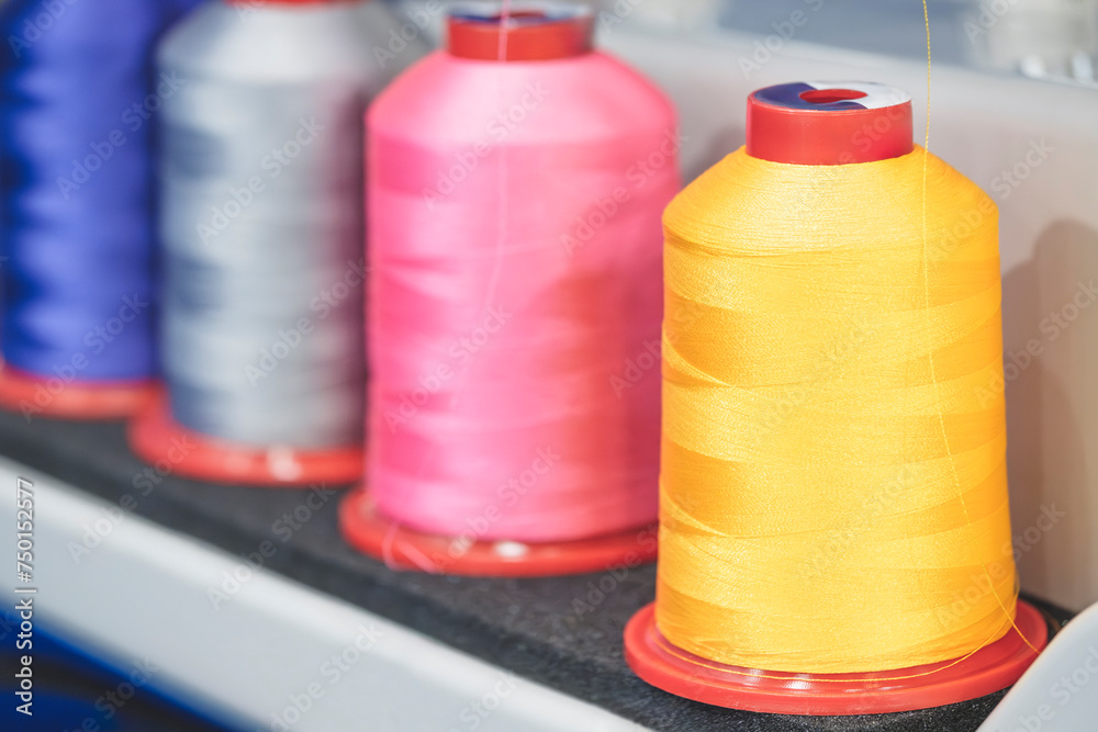 Aufkleber Spools of color threads closeup, spinning machine