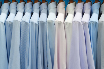 Multi-colored men's shirts on hangers in a store or store - 750152584