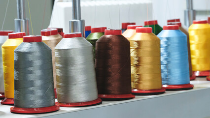 Spools of color threads closeup, spinning machine - 750152790