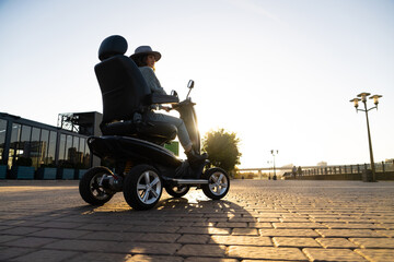 Woman tourist riding a four wheel mobility electric scooter on a city street © scharfsinn86