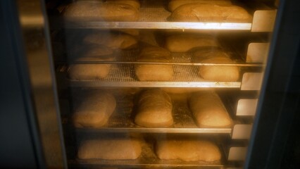 Professional kitchen equipment. Loaves of bread in an industrial oven. The bread is baked in an...