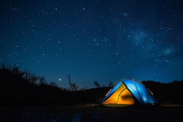 A blue and orange tent is set up in a field at night